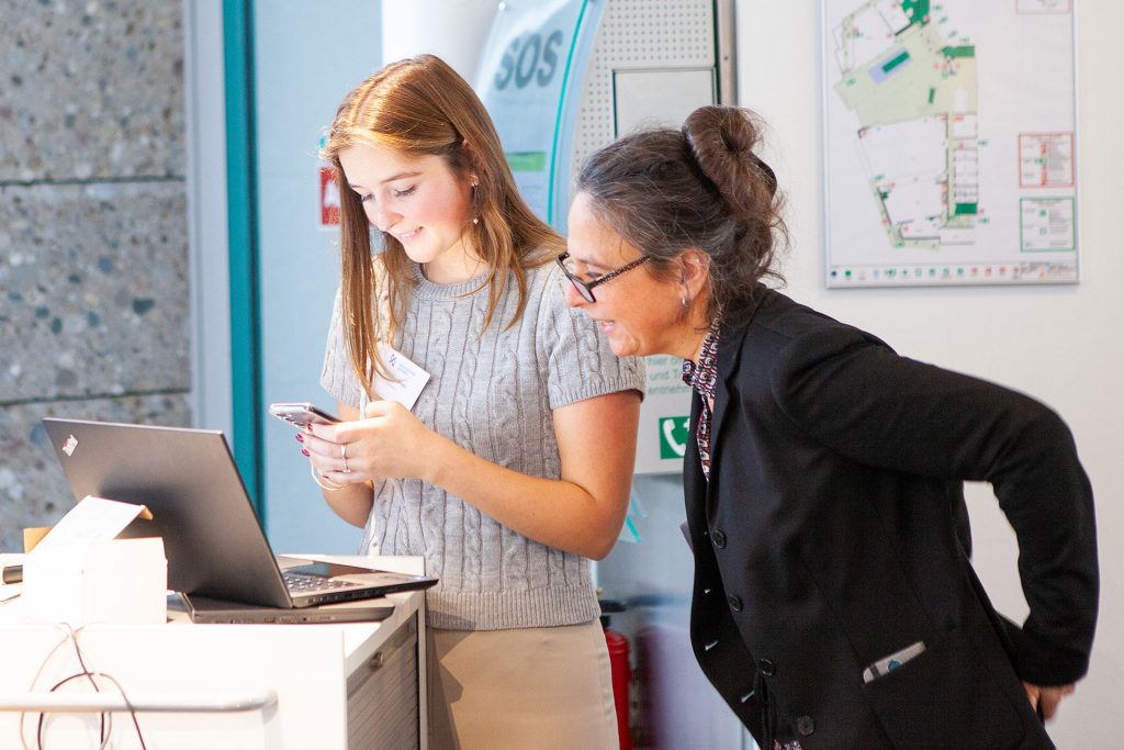 Mitarbeiterinnen am Laptop und Handy